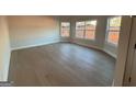 Bright living room featuring light hardwood floors, multiple windows with backyard views, and neutral wall paint at 8795 St Patrick'S Way # 2, Winston, GA 30187