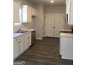 White kitchen cabinets, stainless steel appliances, and dark wood floors at 9168 Carr Cir, Covington, GA 30014