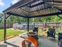 Relaxing patio with fire pit, pool, and wicker furniture at 10 Toscanno Dr, Covington, GA 30014