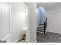 Powder room with pedestal sink and dark wood staircase at 3170 Fareed St, Douglasville, GA 30135
