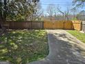 Fenced backyard with a driveway and sparse grass lawn at 1551 Ferno Nw Dr, Atlanta, GA 30318