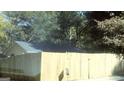 Fenced backyard featuring a partial view of the house and mature trees at 1551 Ferno Nw Dr, Atlanta, GA 30318