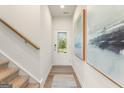 Bright hallway featuring hardwood floors, a white door with glass, and tasteful artwork on the walls at 1935 Westwind Street # 157, Lawrenceville, GA 30043