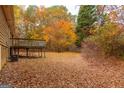 Spacious backyard with deck and surrounding trees in autumn at 2949 Hog Mountain Rd, Dacula, GA 30019
