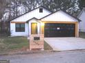 Modern craftsman style home with black garage doors and a landscaped yard at 4490 Latchwood Dr, Lithonia, GA 30038