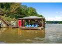 Wooden boat dock with covered area, seating, and multiple boats visible at 440 Yancey Cir, Covington, GA 30014