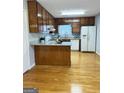 Galley style kitchen with granite countertops and wood cabinets at 7665 Antebellum Ln, Riverdale, GA 30274