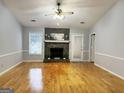 Bright living room with hardwood floors and a stone fireplace at 7665 Antebellum Ln, Riverdale, GA 30274