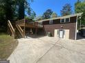 Rear exterior featuring a wooden deck with a concrete patio beneath, and brick and vinyl siding at 2362 Maxwell Dr, Atlanta, GA 30311