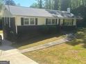 Charming home with a combination of brick and white siding, black shutters, and a well-maintained lawn at 2362 Maxwell Dr, Atlanta, GA 30311