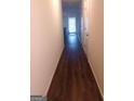 Long hallway with dark hardwood floors and access to other rooms at 6258 Ellenwood Dr, Rex, GA 30273