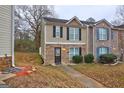 Two-story townhome with stone and vinyl siding, featuring a walkway and landscaping at 8424 Carlington Ln, Jonesboro, GA 30236