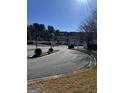 Gated community entrance with curved driveway and landscaping at 6022 Centennial Run, Atlanta, GA 30349
