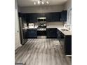 Modern kitchen with dark blue cabinets, stainless steel appliances, and white countertops at 6022 Centennial Run, Atlanta, GA 30349