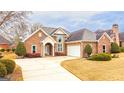 Brick house with a two-car garage and landscaping at 320 Oakpark Ter, Mcdonough, GA 30253