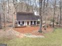 White farmhouse nestled in a wooded area with a stone border at 315 Countryside, Mcdonough, GA 30252