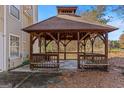 Wooden gazebo with a shingled roof and benches at 360 Kaleb C, Mcdonough, GA 30252