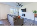 Living room with gray sectional sofa, electric fireplace, and wood-look floors at 177 Swindon Dr, Mcdonough, GA 30253