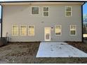 Rear exterior of the home featuring light gray siding, multiple windows, and a concrete patio area at 2791 Riverchess Ct # 147, Atlanta, GA 30331