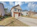 Two-story house with brick and beige siding, a two-car garage, and a driveway at 11945 Lovejoy Crossing Way, Hampton, GA 30228