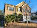 Attractive two-story home shows large bushes, a two-car garage, and a manicured front yard at 5150 Amberland Sq, Atlanta, GA 30349