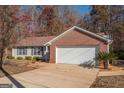 Brick ranch house with attached garage and a spacious driveway at 74 Canterbury Dr, Grantville, GA 30220