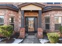 Front entrance with a glass door and brick facade at 704 Kitts Ct, Mcdonough, GA 30253