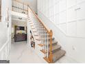 Elegant staircase with a built-in shelf and marble flooring at 308 Royal Crescent Way, Stockbridge, GA 30281