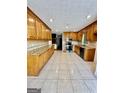 Kitchen with granite countertops, oak cabinets, and tile flooring at 2735 Sandy Creek Cir, Loganville, GA 30052