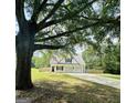 White house with gray metal roof, three-car garage, and a long driveway at 470 Harris Rockmore Loop, Covington, GA 30014