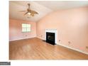 An empty living room with hardwood floors, a fireplace, and a ceiling fan at 5738 Antelope Trl, Atlanta, GA 30349