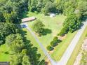 Aerial view of a property showcasing the brick home, outbuilding, garden, and expansive yard at 677 Gum Creek Rd, Oxford, GA 30054