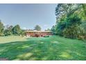 Wide view of a large backyard and back of the home with a deck and patio area at 677 Gum Creek Rd, Oxford, GA 30054