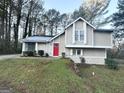 Two-story house with red door, light beige siding, and green lawn at 3951 Wabash Ln, Ellenwood, GA 30294