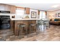 Modern kitchen with island, dark cabinets, and wood-look floors at 58 Pinewood Dr, Carrollton, GA 30116