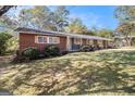 Newly renovated ranch home with brick and gray siding, showcasing a landscaped lawn at 1091 Pine St, Conyers, GA 30012