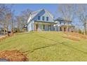 Two story house with light blue siding, red door and a front porch at 3165 Old Jonesboro Rd, Hapeville, GA 30354