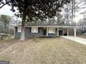 Gray ranch home with carport, situated on a grassy lot at 121 Pine Forest Dr, Dallas, GA 30157