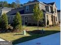 Two-story home with stone and brick exterior, showcasing a well-manicured lawn at 596 Silver Moon Drive, Loganville, GA 30052