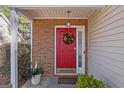 Inviting entryway featuring a red door with a decorative wreath, and sidelight window at 3700 Mays Sw Xing, Atlanta, GA 30331