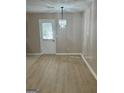 Bright dining area with chandelier and laminate flooring at 7983 Trinity Park Dr, Riverdale, GA 30296