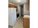 Galley kitchen with wood cabinets and modern appliances at 7983 Trinity Park Dr, Riverdale, GA 30296