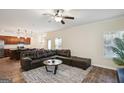 Spacious living room with dark leather sofa, ceiling fan, and views of the kitchen at 429 Burgundy Se Ter, Atlanta, GA 30354