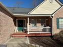 Brick front porch with green door and white railing at 504 Plantation Creek Dr, Loganville, GA 30052