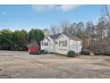 Side view of the house showcasing a large yard and wooded area at 718 Grove Pointe Cir, Locust Grove, GA 30248
