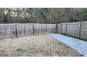 Fenced backyard with patchy grass and a section covered in snow at 2408 Centenary Way Ct, Dacula, GA 30019
