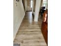 Bright hallway with light wood-look flooring, showing access to the living room and stairs at 2408 Centenary Way Ct, Dacula, GA 30019