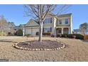 Two-story house with a large yard, two-car garage, and landscaping at 704 Pine Grove Cir, Peachtree City, GA 30269