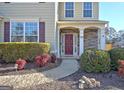 Charming front entrance with stone accents, manicured landscaping, and a welcoming walkway to the front door at 704 Pine Grove Cir, Peachtree City, GA 30269