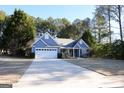 Front view of a charming blue house with a two-car garage at 756 Stonehaven Chase, Mcdonough, GA 30253